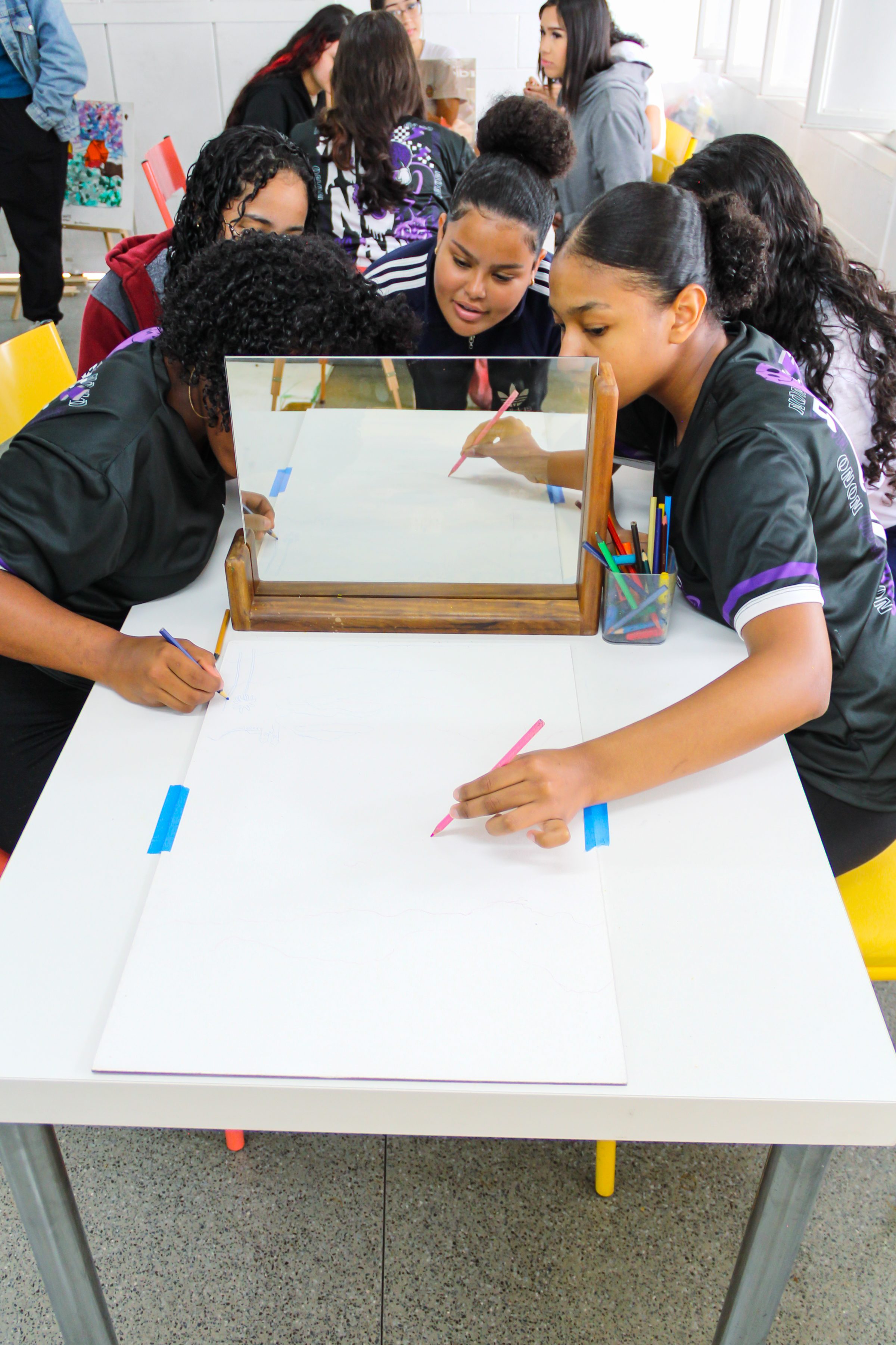 Students drawing with the help of a mirror