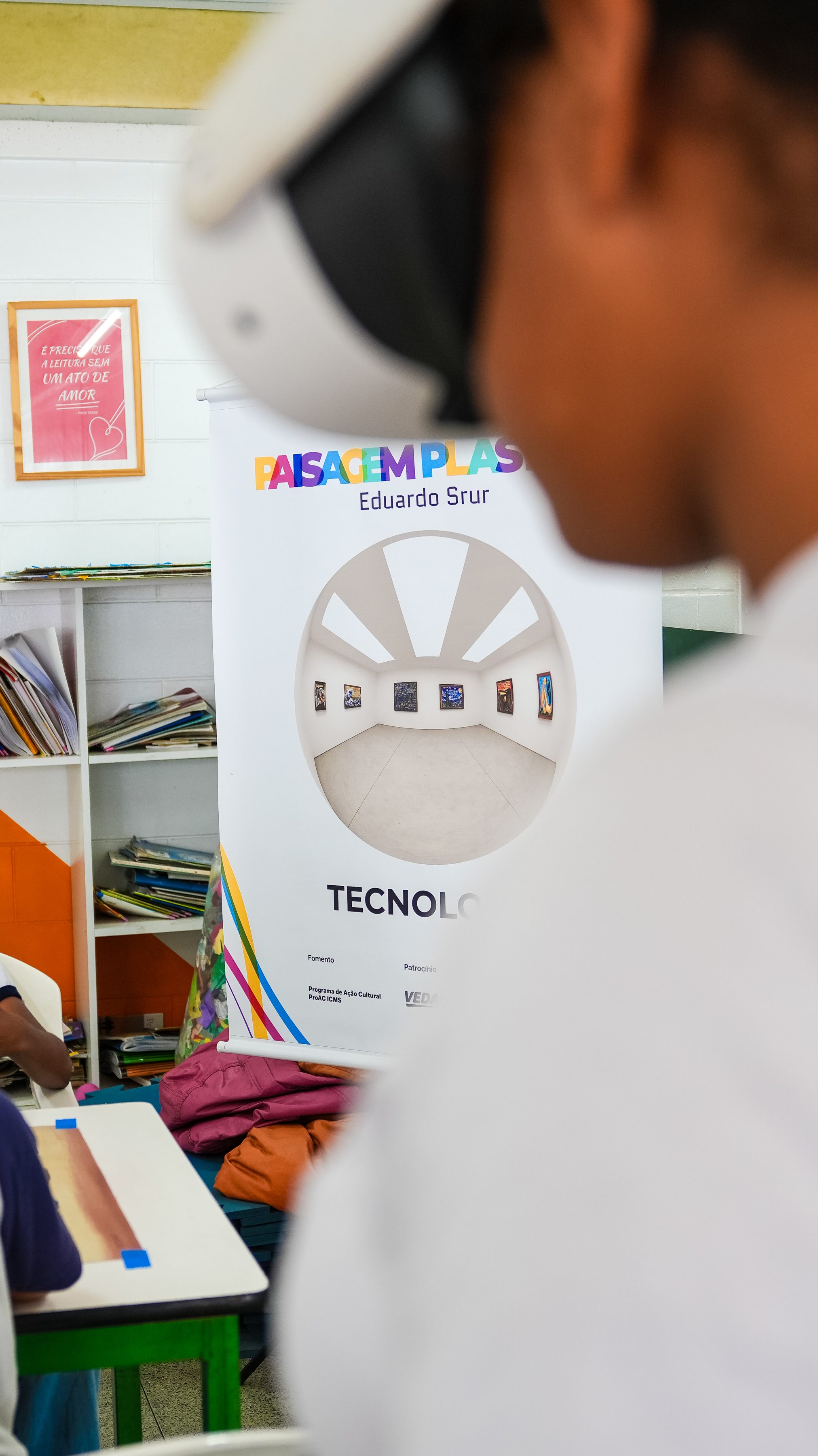 Student wearing virtual reality glasses in front of the project's Technology banner